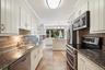 Updated kitchen with granite counters, stainless steel appliances and island with storage