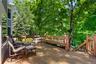 Area of deck with stairs down to hot tub, pool and patio.