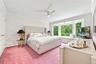 Fourth Bedroom with ceiling fan, laundry chute, two double wide closets, bay window with seat