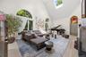 Bright Living Room with arched entry, hardwood flooring, recessed lights, two skylights, ceiling fan, B/I cabinets, wood burning Fireplace with granit