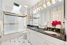 Second Hall Bathroom with two sink vanity, skylight, bathtub, mirrored medicine cabinet