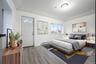 Bedroom featuring a baseboard heating unit and wood finished floors