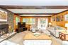 Rustic Farmhouse Den with Stone Fireplace and vaulted beam ceiling.