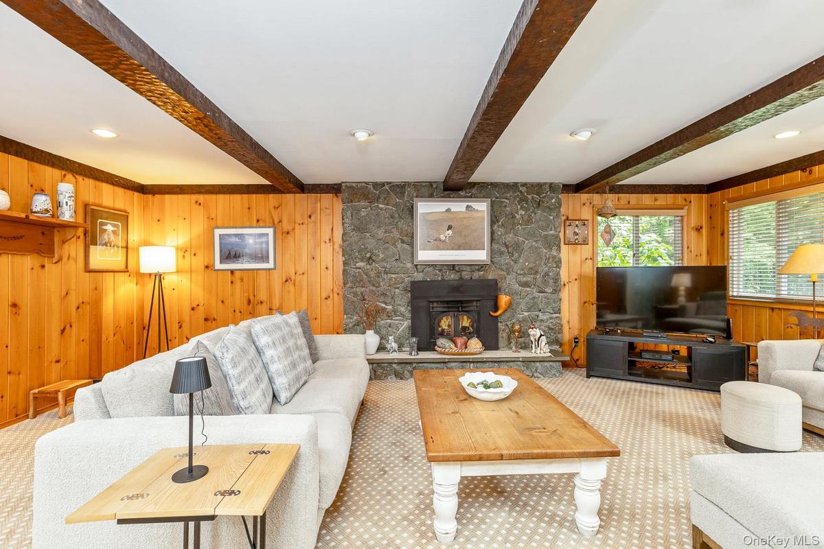 Rustic Farmhouse Den with Stone Fireplace and vaulted beam ceiling.