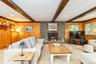 Rustic Farmhouse Den with Stone Fireplace and vaulted beam ceiling.