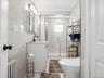 Updated full bathroom featuring a modern vanity, glass-enclosed shower, and sleek tiled finishes.
