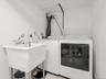 Laundry appliances with a utility sink featuring a chrome faucet
