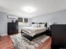 Primary Bedroom: Spacious and bright with hardwood floors, recessed lighting, multiple windows, and a split A/C unit.