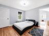 Comfortable bedroom featuring hardwood floors, ample natural light, and radiator heating.