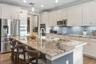 The kitchen features a spacious island with comfortable seating, creating the perfect spot for casual meals, morning coffee, or gathering with family 