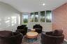 Vaulted ceiling, recessed lighting, exterior access door, a wall of multiple windows, and accent wall with patterned wall covering