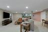 Recessed lighting illuminating a spacious carpeted area, featuring an accent wall and a built-in entertainment stand