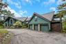 Contemporary exterior with a multi-level roofline, attached three-car garage, upper-level balcony, and a paved driveway