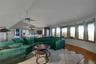 Vaulted ceiling with a ceiling fan, wood-finish flooring, and a wall of windows
