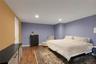 Recessed lighting, wood-finish flooring, and a white door with contemporary hardware