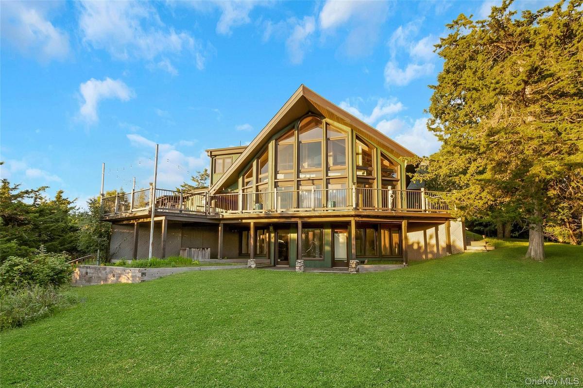A-frame architectural style with extensive glazing, elevated outdoor decking, and ground-level access