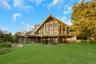 A-frame architectural style with extensive glazing, elevated outdoor decking, and ground-level access