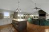 Open-concept living area featuring wood-finish flooring, a kitchen island with built-in microwave, an integrated fireplace, and a vaulted ceiling with