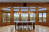 Hardwood flooring, wood-paneled walls, exposed wood beams, and a chandelier lighting fixture