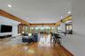 Hardwood flooring, exposed wooden beams, recessed lighting, expansive windows, and a built-in bar