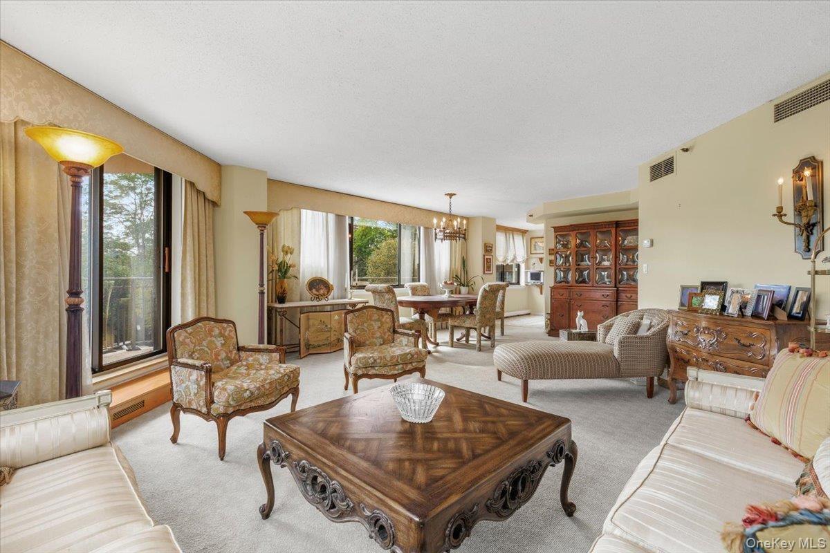 Sun-filled iving and dining areas with 2 sets of glass doors to wrap around balcony.