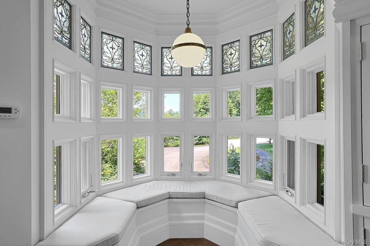 This cozy, bright bay window seat is an amazing spot to laze and read. The stained glass detail on the windows of the tower, which continues up to the