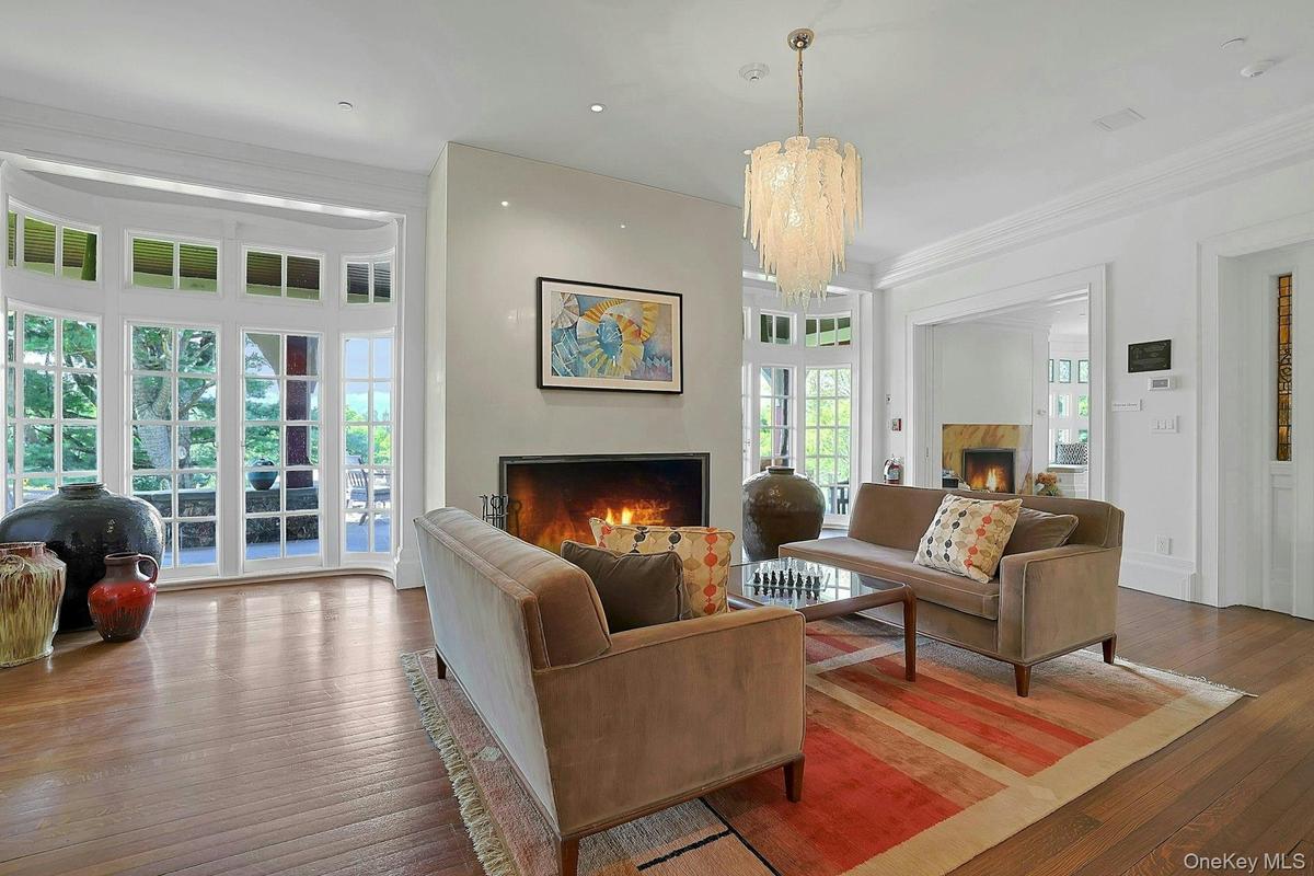 With a stunning, contemporary glass chandelier and walls of original windows and French doors, the expansive living room is a warm heart to the home.