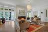 With a stunning, contemporary glass chandelier and walls of original windows and French doors, the expansive living room is a warm heart to the home.
