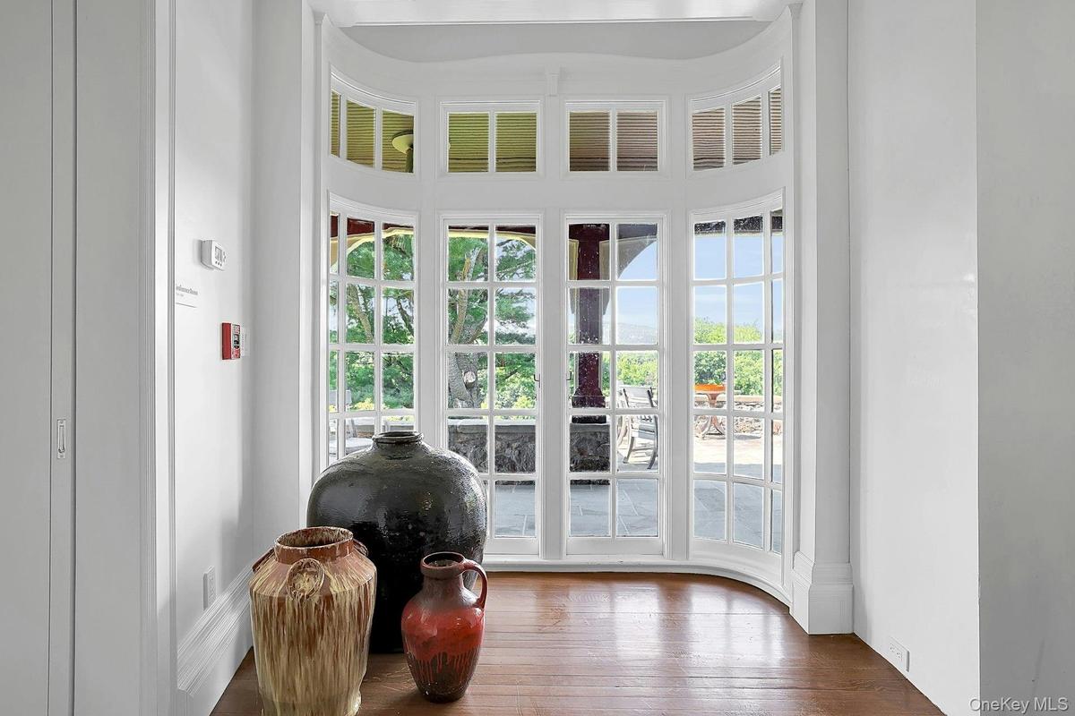 A closer look at the restored original 1800's doors, which open out to the large slate porch and patio beyond. Light shines off of the original hardwo