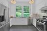 Four beautiful, matching glass fixtures cast warm light down. There is also convenient under-cabinet lighting here. There is ample cabinet space and t