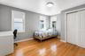 Hardwood flooring, painted walls, two windows with roller shades, and a flush mount ceiling light