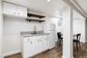 Cabinetry with black hardware, hexagon tile backsplash, wood-finish flooring.