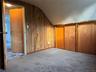Sloped ceiling with recessed lighting, wood-finish wall paneling, and sliding wood-finish closet doors