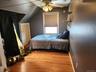 Wood-finish flooring, a ceiling fan with integrated lighting, and shelving