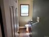 Bathroom featuring a dark wood finish vanity with a dark countertop, white toilet, and a window with a blind