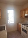 Kitchen featuring wood-finish cabinetry, white countertops, stainless steel sink, and a gas range