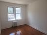Hardwood-finish flooring, white painted walls, and a window with white trim
