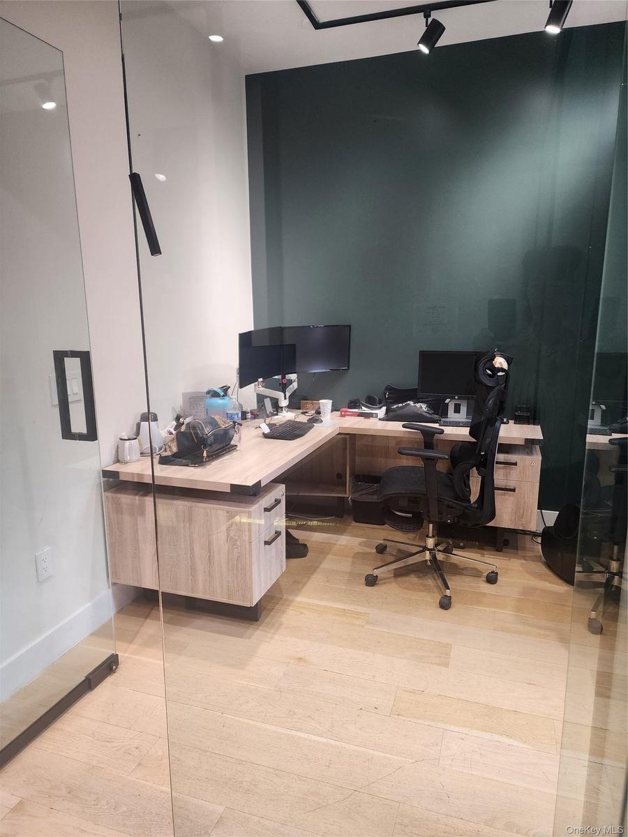 Wood-finish flooring with a glass partition wall and track lighting