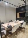 Integrated track lighting system, built-in media console with light wood-finish accent, dark cabinetry, glass partition, and wood-finish flooring