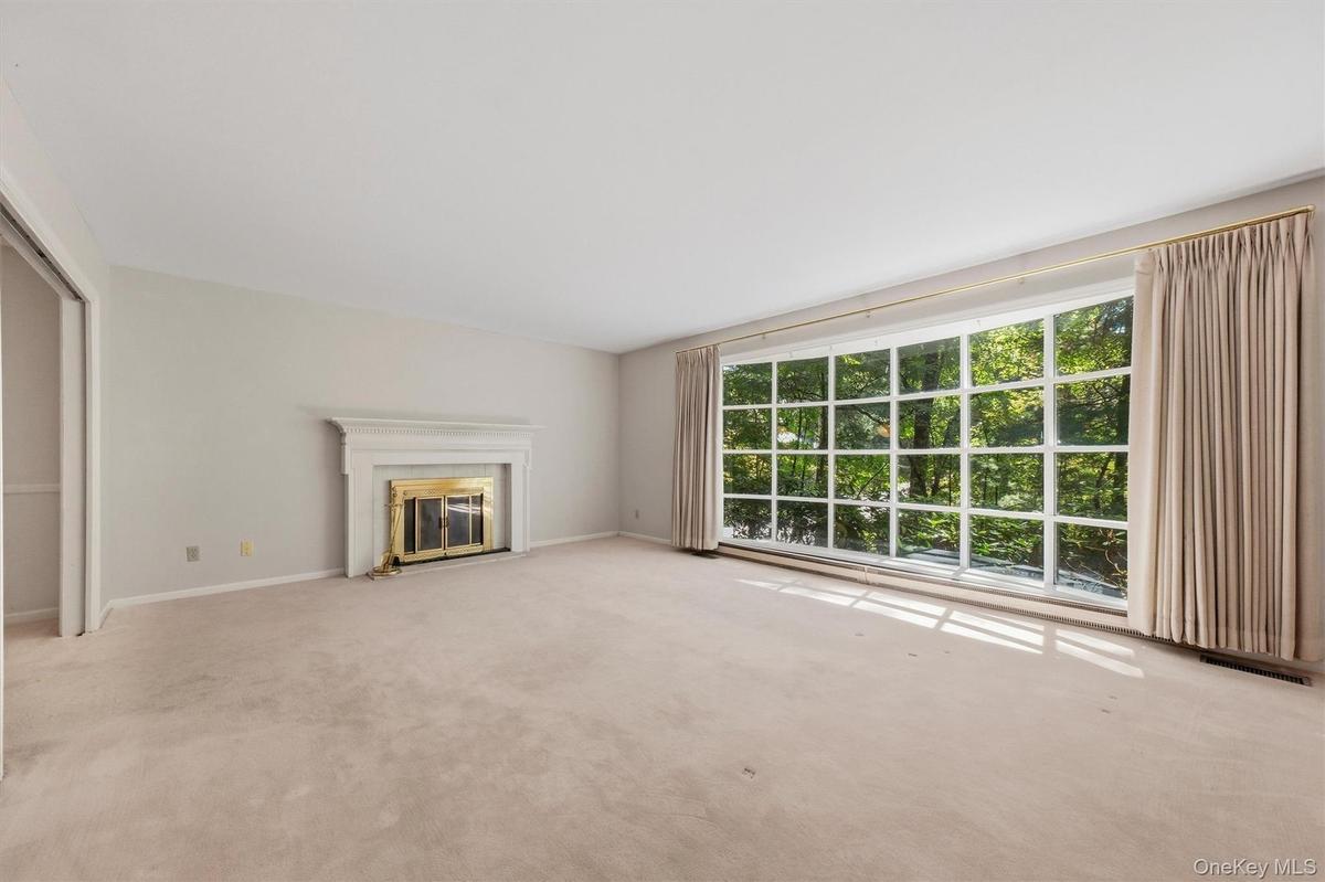 Expansive formal living room with large bow window and wood burning fireplace. Hardwood under carpet.