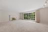 Expansive formal living room with large bow window and wood burning fireplace. Hardwood under carpet.