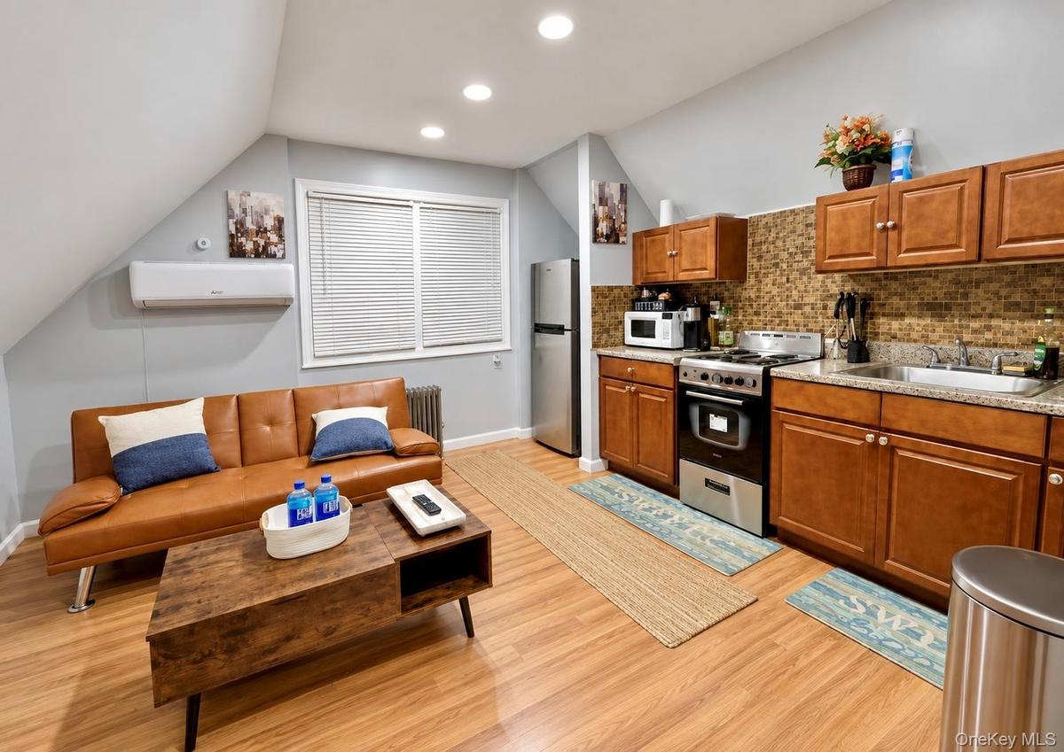 Second-floor bedroom utilized as a kitchen and living room area.