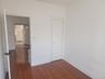 Wood-finish flooring with white base trim, white walls, and a white closet door