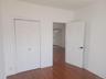 Wood-finish flooring with white trim and white walls