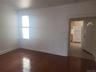 Wood-finish flooring, recessed lighting, and a white interior door with an arched window accent