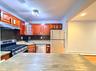 Kitchen featuring wood-finish cabinetry, stainless steel appliances, granite countertops, and a tile backsplash