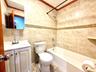 Tiled bathroom featuring a white vanity with integrated sink, chrome fixtures, a tiled shower, and mosaic accent tiling