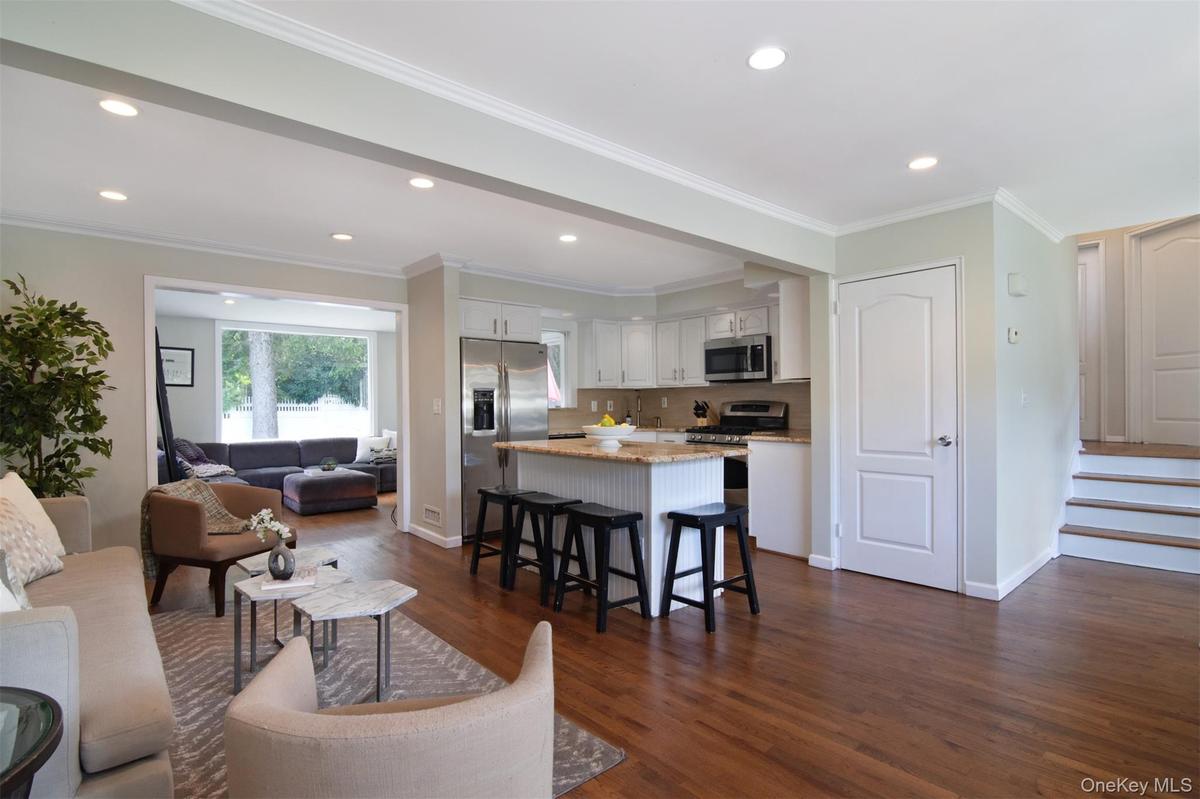 Great room area with den in the left back and on the right, steps up to the first bedroom level