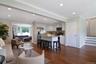 Great room area with den in the left back and on the right, steps up to the first bedroom level