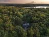 View of subject property featuring a heavily wooded area and a large body of water